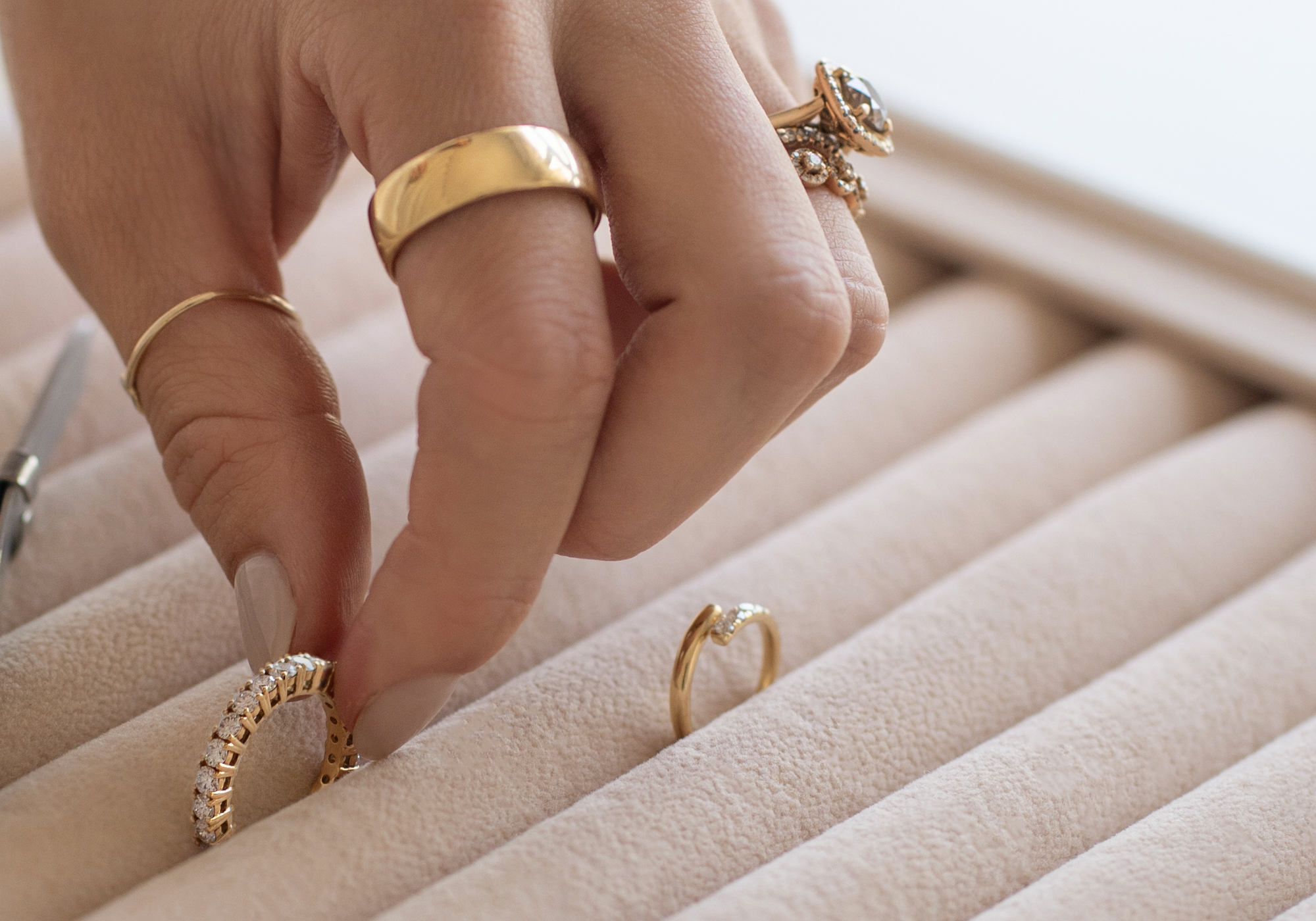 Picking from a selection of gold diamond wedding rings