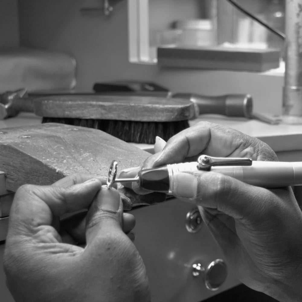 Close-up of hands crafting a small jewelry piece using tools in a Saint Stone workshop in Australia