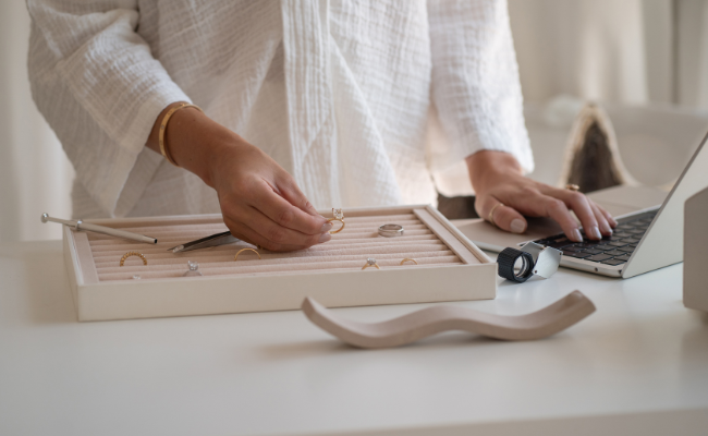 Saint Stones founders working on jewellery design with a laptop on a desk.