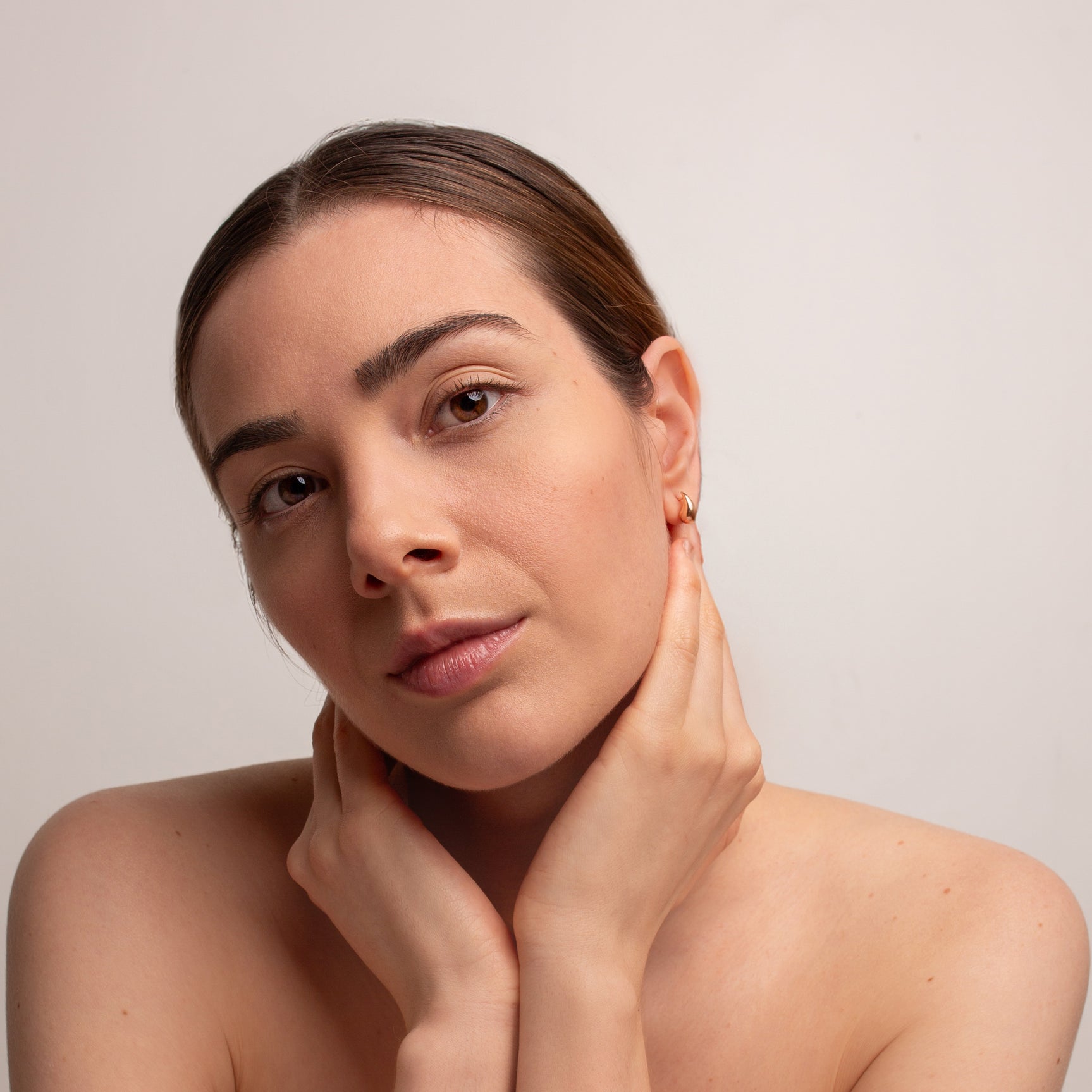 Woman wearing a tear drop gold stud earring