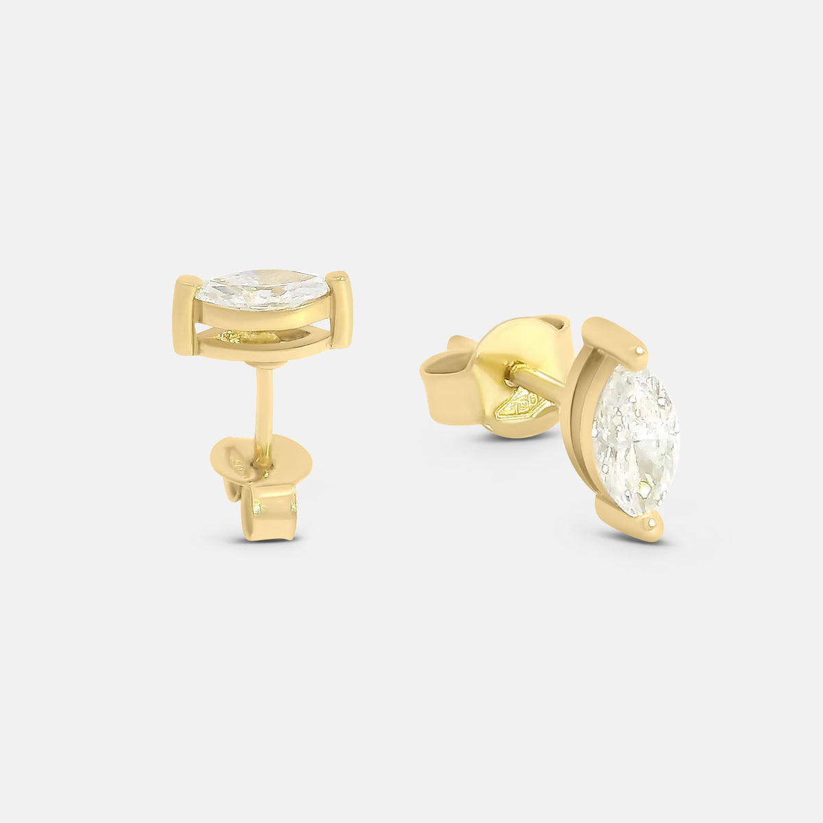 Gold stud earrings with diamonds on a light grey background