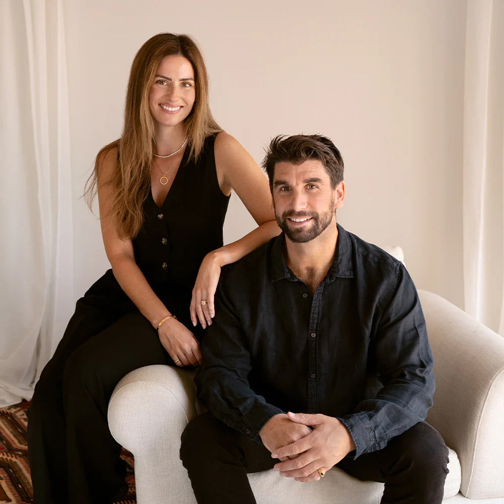 Saint Stone founders Ashlynne and Ben sitting together on a couch in a well-lit room, Australian luxury jewelry brand lifestyle image