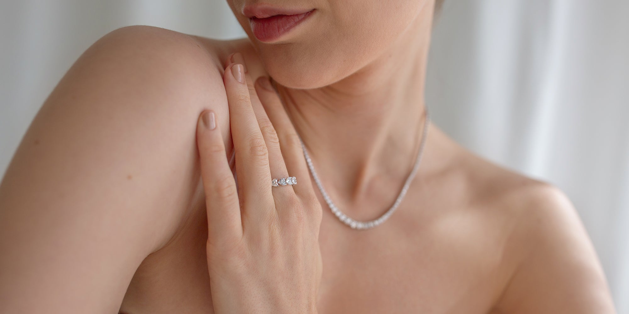 Saint Stone model wearing a silver necklace and matching ring, luxury Australian jewelry photoshoot with blurred background